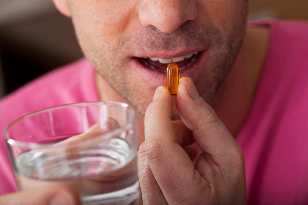 en mann tar vitaminer for å forbedre nervesystemets funksjon